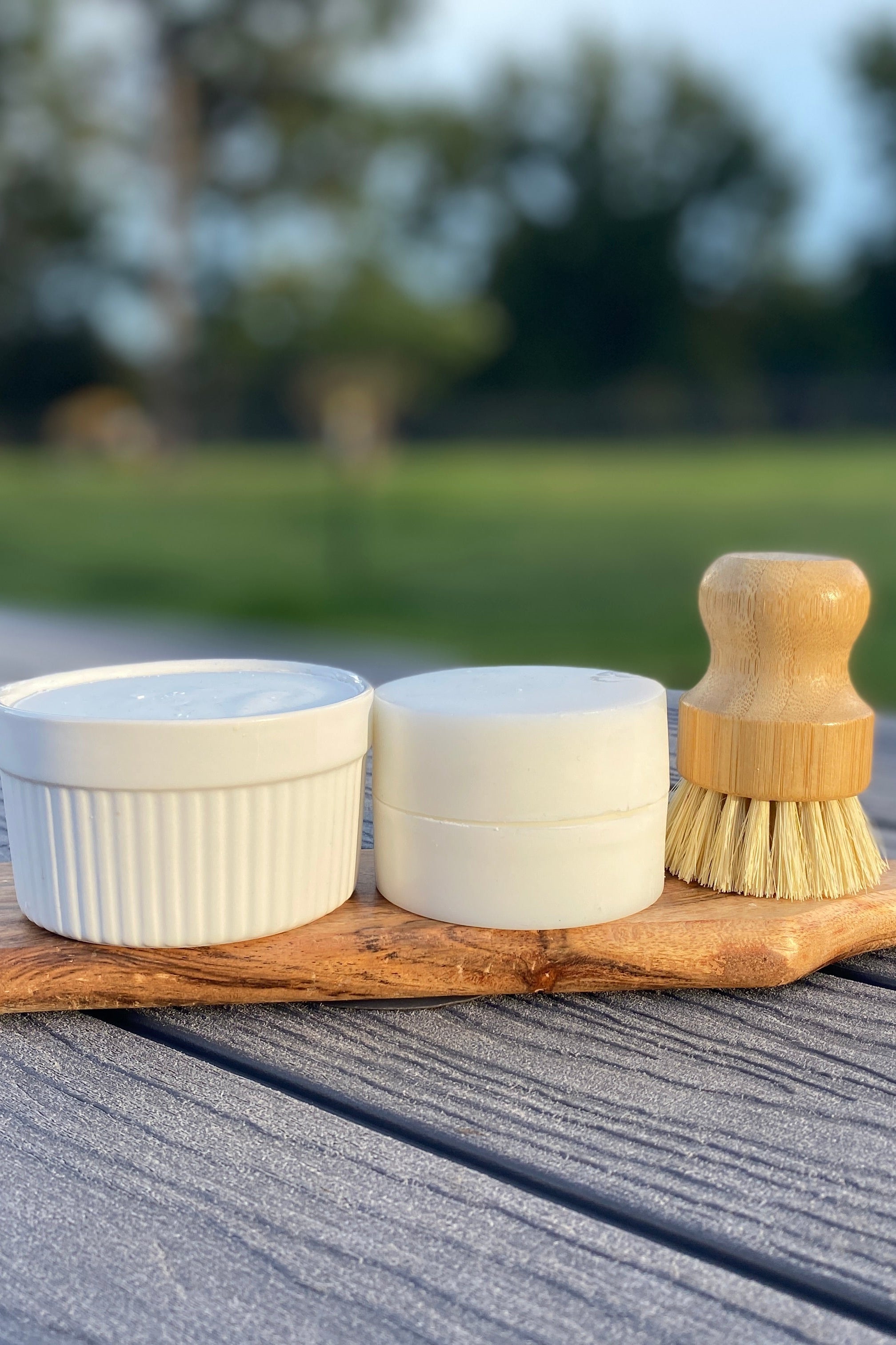The complete fragrance free solid dish soap set sitting on a wooden board in a natural setting
